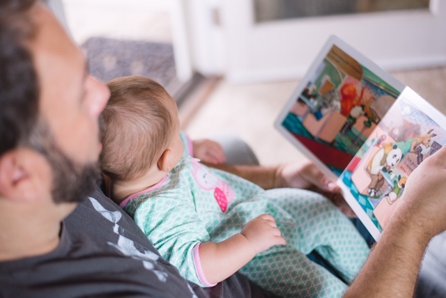 Vater zeigt seinem Baby ein Bilderbuch