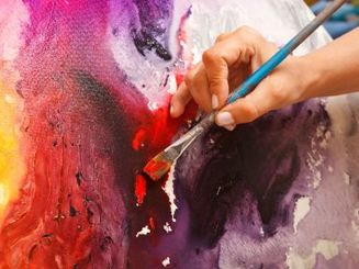 Künstlerin trägt Acrylfarben auf Leinwand auf