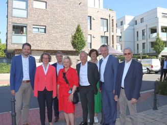 NRW-Bauministerin Ina Scharrenbach (2.v.l.) lässt sich von Bürgermeister Christian Bommers sowie Vertretern der beteiligten Bauträger das Gemeinschaftsprojekt "Wohnen am Schackumer Bach" näher vorstellen.